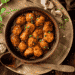 Saucy Asian Meatballs Appetizer In A Wooden Bowl With Garlic, Sesame Seeds, And Wooden Spoon On The Side