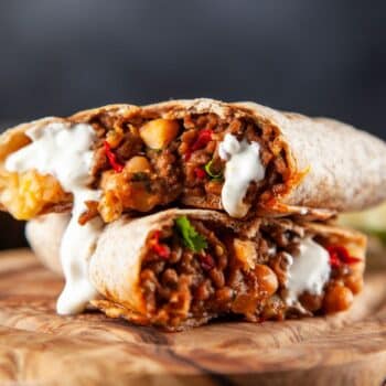 The Best Beef And Veggie Burrito Sliced In Half Exposing The Beef Mixture