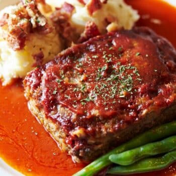 Ground Beef Meatloaf Recipe On A Plate With Mashed Potato And String Beans