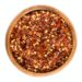 Dried Chili Pepper Flakes In Wooden Bowl Over White