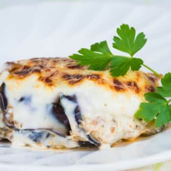 Classic Moussaka Served On A White Plate With Creamy Béchamel Sauce